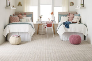 Columbia | The Design Emporium Twin bedroom with two single beds, pastel pillows, and a shared desk between them by a bright window.