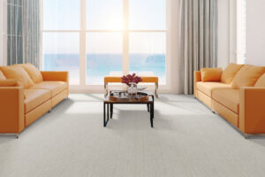 Mixed Media | The Design Emporium Bright living room with two orange sofas facing a central coffee table, large windows with an ocean view.